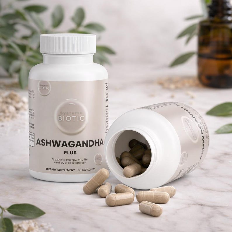 May include: Two white supplement bottles with the text "ASHWAGANDHA PLUS" and "SYSTEME BIOTIC". One bottle is upright, the other is tipped over, spilling brown capsules. The capsules are scattered on a white surface.