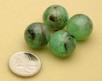 May include: Four spherical glass beads featuring a translucent light green base with swirling dark brown and white marbled patterns. A silver-colored Canadian 25-cent coin is positioned next to the beads to provide a sense of scale for the items.