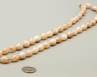 May include: A single-strand necklace composed of round, polished beads in shades of cream, beige, and light brown with a marbled appearance. The beads are strung together and feature a small gold-toned metal clasp at the end of the necklace.