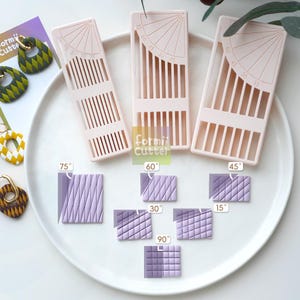 May include: Three pale pink plastic clay cutters with integrated angle guides ranging from 15 to 75 degrees. The tools feature parallel slots for precise cutting. Below, six purple clay squares demonstrate various embossed grid patterns labeled 15, 30, 45, 60, 75, and 90 degrees. The text Formii Cutter is visible.