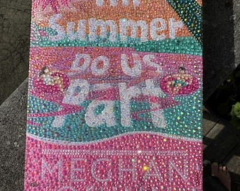 May include: A rectangular canvas art piece with the text "Till Summer Do Us Part" and "Meghan Quinn" in white, embellished with pink, orange, teal, and green rhinestones. The artwork has a sparkling, textured appearance.