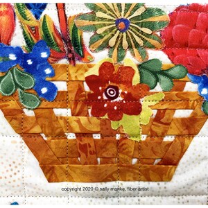Puede incluir: Primer plano de una cesta tejida de tela llena de flores de tela de colores. La cesta est&aacute; hecha de tela marr&oacute;n y naranja y est&aacute; acolchada con hilo marr&oacute;n. Las flores est&aacute;n hechas de varias telas, incluyendo rojo, amarillo, azul y verde. El texto "copyright 2020 &copy; sally manke, fiber artist" es visible en la parte inferior de la imagen.