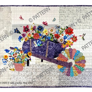 Op de afbeelding: Een paarse kruiwagen die overloopt met kleurrijke bloemen, waaronder rode, roze, gele en blauwe bloemen. De kruiwagen staat op een witte achtergrond met een grijs en wit patroon. De tekst "copyright 2020 sally manke, fiber artist" staat onderaan de afbeelding.