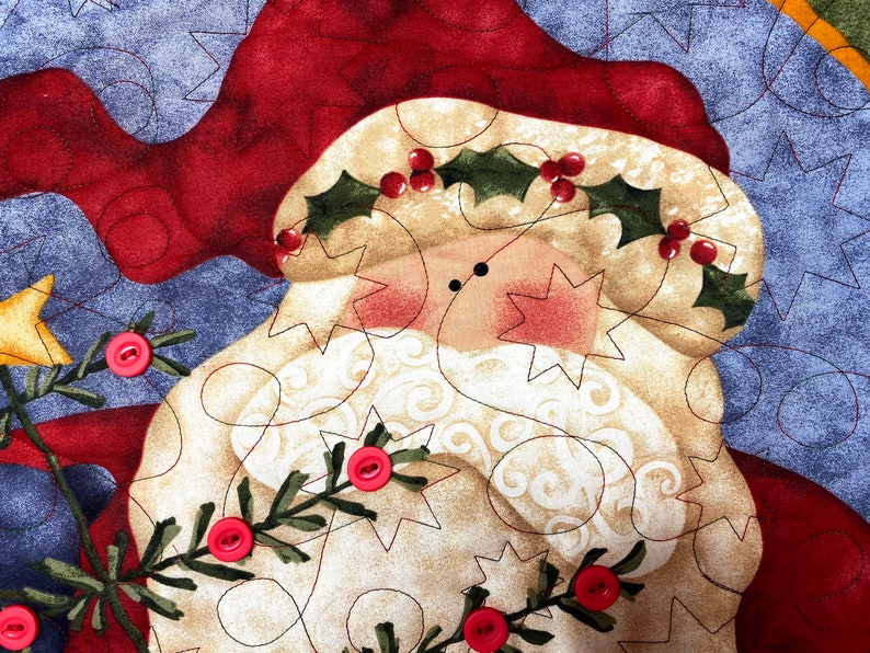 Exquisitely quilted vintage advent calendar featuring Santa Claus holding a Christmas Tree. Twenty-four buttons have been securely stitched to hang the cotton and felt ornaments day each day leading up to Christmas. Nancy Halverson holiday panel.