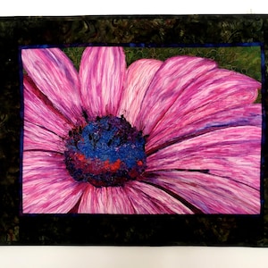May include: A close-up of a pink flower with a dark purple centre. The flower is surrounded by a dark green frame.