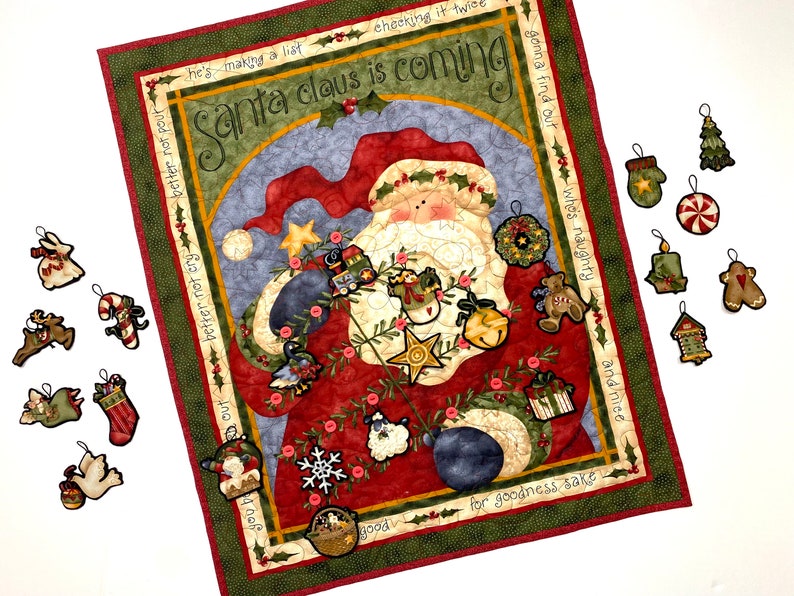 Exquisitely quilted vintage advent calendar featuring Santa Claus holding a Christmas Tree. Twenty-four buttons have been securely stitched to hang the cotton and felt ornaments day each day leading up to Christmas. Nancy Halverson holiday panel.