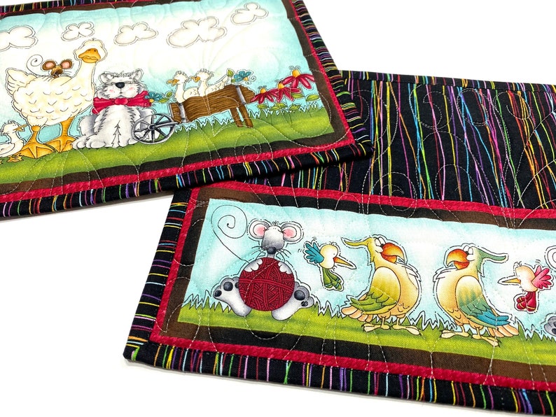 Set of two quilted mini placements or large mug rugs with sweet animal designs that include dog, goose, mice birds and flowers. Printed panels are accented with multi-colored pinstriped fabric on black background. Each mat measure 10-1/2 X 8-1/2