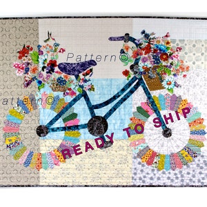 May include: A blue bicycle with a basket full of colorful flowers. The bicycle wheels are made of patchwork fabric with a "READY TO SHIP" message on the front wheel.