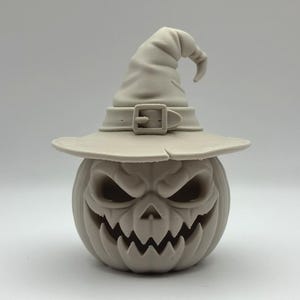 Può includere: Decorazione di Halloween grigio chiaro con una zucca intagliata con una faccia arrabbiata, che indossa un cappello da strega. Il cappello ha una fibbia e un'ampia tesa. La zucca ha una bocca frastagliata e orbite profonde.