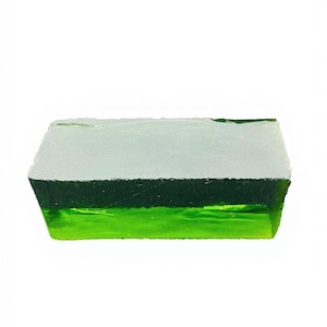 Op de afbeelding: Een rechthoekig, gelaagd glazen stuk met een kleurengradatie. De bovenste laag is een licht, mat wit, overgaand in een donkergroen midden, en een levendige, heldergroene basis. De randen zijn ruw en getextureerd.