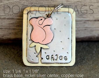 May include: A brass dog tag with a copper rose design and a nickel silver center. The tag is 1 1/4 inches by 1 1/8 inches and has the name "Chloe" engraved on it.