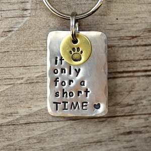 Peut inclure: Porte-clés en argent avec un charme en forme de patte et le texte "if only for a short TIME" avec un cœur.