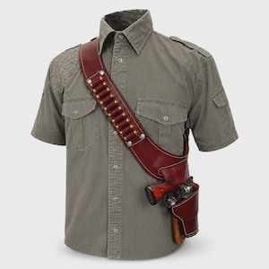May include: A short-sleeved olive green button-down shirt with two chest pockets and shoulder epaulets, worn with a dark brown leather shoulder holster featuring a diagonal bandolier strap holding twelve metallic cartridges and a side holster.