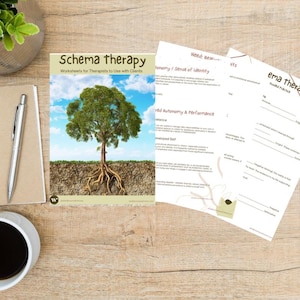 May include: A workspace featuring a notebook, pen, and a cup of coffee. A book titled "Schema Therapy" with a tree graphic is visible, along with worksheets. The scene is set on a wooden surface, with a small plant in the background.