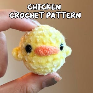 Może przedstawiać: Ręcznie robiony, żółty szydełkowy kurczak z okrągłym korpusem, małym pomarańczowym dziobem i czarnymi oczami. Tekst "CHICKEN CROCHET PATTERN" jest wyświetlany nad kurczakiem. Kurczak jest trzymany między dwoma palcami.