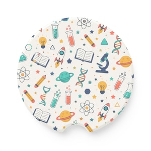 May include: A circular car coaster featuring a cream-colored background with a repeating pattern of colorful science-themed icons including rockets, planets, DNA strands, microscopes, light bulbs, open books, pencils, and test tubes.