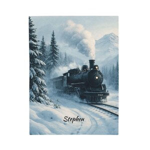 May include: A rectangular print featuring a black steam locomotive traveling through a snowy mountain landscape with evergreen trees and a plume of white smoke. The name Stephen is printed in black script at the bottom of the snowy foreground.