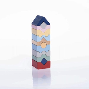 May include: A wooden stacking toy in a variety of pastel colours. The toy is made up of different geometric shapes, including a house-shaped top. The base is red, with layers of blue, grey, green, light blue, natural wood, yellow, and navy blue.