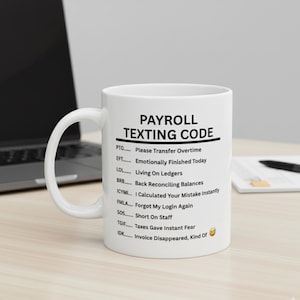 Könnte beinhalten: Weiße Keramik-Tasse mit dem Text "PAYROLL TEXTING CODE" und einer Liste von Akronymen mit ihren Bedeutungen. Die Tasse steht auf einer hellen Oberfläche, mit einem Laptop und einem Notizblock im Hintergrund.