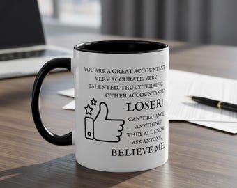May include: White ceramic mug with a black interior and handle. The mug features text that reads "YOU ARE A GREAT ACCOUNTANT...LOSER! CAN'T BALANCE ANYTHING! BELIEVE ME" with a thumbs-up graphic.