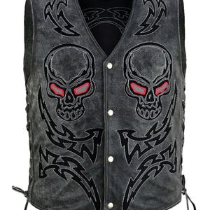Puede incluir: Un chaleco gris con cuello en V y cierre de botones. El chaleco presenta dos diseños de calaveras con ojos rojos y patrones tribales negros. Los lados tienen cordones para ajustar. Un chaleco único de estilo motero.
