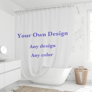 Puede incluir: Cortina de ducha blanca con el texto "Your Own Design, Any design, Any color" en azul. La cortina cuelga frente a una bañera blanca. También se ven un tocador blanco y una cesta de mimbre.