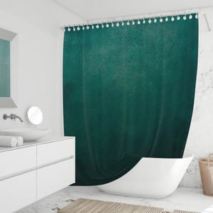 Puede incluir: Una cortina de ducha de color turquesa con apariencia texturizada cuelga en un baño moderno. La cortina está suspendida de una barra blanca con ganchos decorativos blancos en forma de bola. El baño cuenta con un tocador, lavabo y bañera blancos.