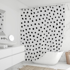 Puede incluir: Una taza de cerámica blanca con un asa negra y el texto "But First, Coffee" en negro y negrita. La taza está sobre una superficie blanca.