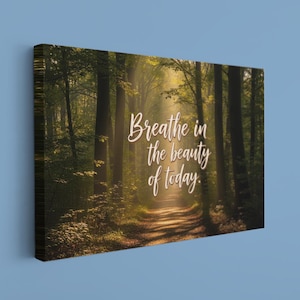 May include: Canvas art print featuring a forest path bathed in sunlight. The image displays tall trees and a pathway leading into the distance. The text "Breathe in the beauty of today" is written in a cursive font.