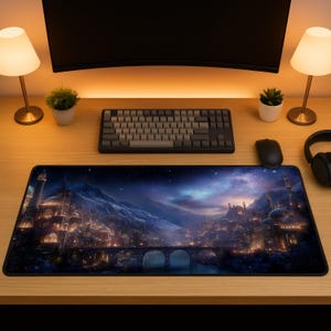 May include: A rectangular desk mat featuring a detailed illustration of a fantasy city at night with illuminated buildings, a stone bridge over water, and snow-capped mountains under a starry, deep blue and purple nebula sky.