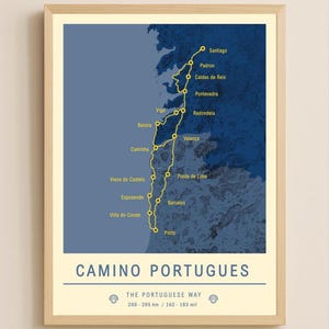 May include: A framed print featuring a map of the Camino Portugues, a pilgrimage route. The map is in shades of blue and yellow, with the route marked by a yellow line and labeled with cities like Porto and Santiago. The text "CAMINO PORTUGUES" is at the bottom.