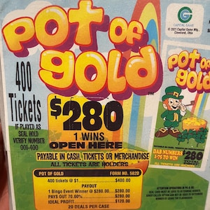 May include: A Pot of Gold scratch-off ticket with a leprechaun illustration. The ticket features the text "Pot of Gold" in large yellow letters, with details about prizes and the number of tickets.
