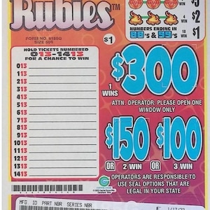 May include: A Red Hot Rubies scratch-off lottery ticket with a $1 price. The ticket features ruby and flame graphics, with potential winnings up to $300. The ticket has a series of numbers to scratch and match.