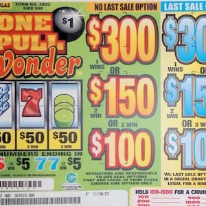May include: A One Pull Wonder pull-tab game card with a light green background. The card features a slot machine graphic with diamonds, a red seven, and green limes. It displays prize amounts of $300, $150, and $100 in large orange and blue text.