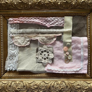 Puede incluir: Un collage enmarcado de diferentes recortes de encaje y tela en tonos rosa, blanco y beige. El collage está decorado con una flor de ganchillo y varios botones.