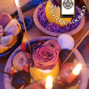 May include: A still life arrangement featuring bowls filled with fruit, a rose, and candles. The text "ESOTERIC VOODOO" is visible. A tarot card is also present, adding to the mystical theme. The scene is illuminated by candlelight.