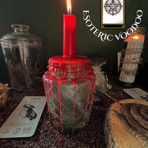 May include: A lit red candle sits atop a glass jar with a diamond pattern, surrounded by red wax drips. The words "ESOTERIC VOODOO" are arched above. Tarot cards and other ritualistic items are arranged around the jar, creating a mystical atmosphere.