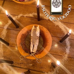 Puede incluir: Una disposición de objetos rituales que incluye un cuenco de arcilla, tijeras y una carta del tarot, rodeada de velas negras encendidas y un círculo de sal. Las palabras "ESOTERIC VOODOO" están arqueadas sobre la escena. Sobre una superficie de madera.