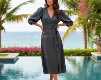 May include: A dark gray wrap dress with a V-neckline and a matching fabric belt. The dress has three-quarter sleeves and a midi length. The text "MAARU CREATION" is visible on the dress. The model is wearing brown sandals.