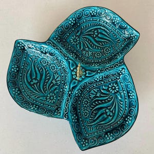 Puede incluir: Un juego de tres cuencos apilables de cer&aacute;mica en tonos azules, verdes y blancos. Los cuencos presentan un esmalte moteado y un dise&ntilde;o sencillo y moderno. El cuenco m&aacute;s grande mide unos 20 cm de di&aacute;metro.