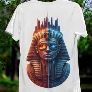 May include: White t-shirt featuring a split graphic of an Egyptian pharaoh with a futuristic cityscape above. One side is orange and red, the other blue. The pharaoh wears high-tech glasses.