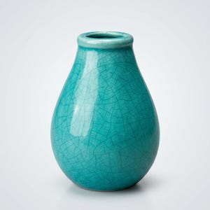 May include: A turquoise ceramic vase with a crackle glaze finish. The vase has a rounded body that tapers to a narrow neck and opening. The vase is approximately 20 cm tall.