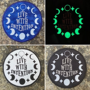 May include: Circular embroidered patches with the text "LIVE WITH INTENTION" surrounded by crescent moons and stars. The patches are shown in blue, glow-in-the-dark green, white and black.