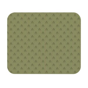 May include: A rectangular mouse pad with rounded corners featuring an olive green background. The surface is decorated with a repeating pattern of vertical dashed lines and dark green chevron arrows pointing upward in a consistent grid arrangement.