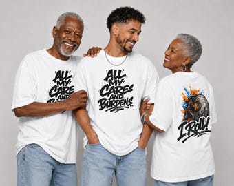 May include: Three people wearing white t-shirts with graphic designs. The front of the shirts read "All My Cares and Burdens" in a stylized font. The back of one shirt features a colorful graphic with the text "I Roll!"