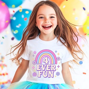 Pode incluir: Uma t-shirt branca de manga curta com uma impressão gráfica colorida de um arco-íris, o número 4 e o texto 4 EVER FUN, rodeado por pequenos ícones de flores e estrelas em tons de rosa, amarelo e azul sobre um fundo branco.