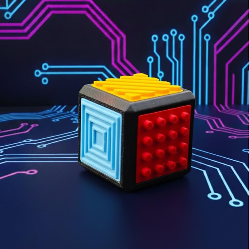 May include: A multi-colored cube with a black frame. The cube features a yellow top with ridges, a blue side with a square pattern, and a red side with raised dots. The background has a circuit board design.