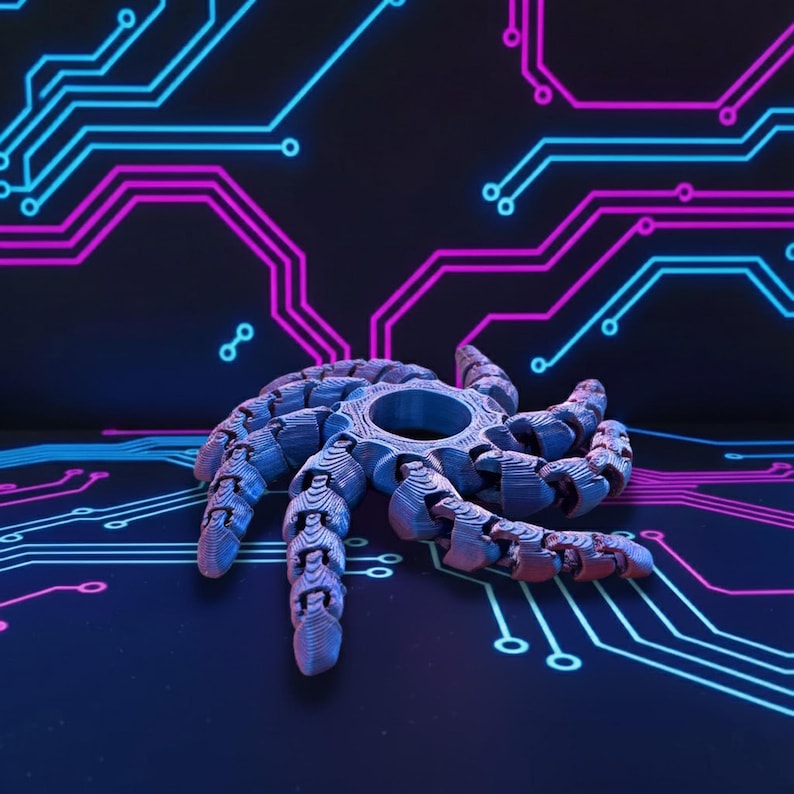 May include: A blue and gray articulated spider toy with a circular center and segmented legs. The toy is set against a dark background with a circuit board design in blue and pink.