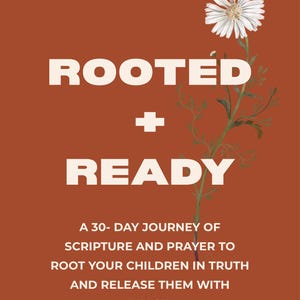 May include: An orange background with the words "ROOTED + READY" in white. A white daisy and green stem are on the right. The text below reads "A 30-day journey of scripture and prayer to root your children in truth and release them with peace."