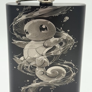May include: Black stainless steel flask with a detailed engraving of a cartoon turtle character surrounded by water. The flask has a silver cap and hinge, and the design is etched in a lighter tone against the dark background.